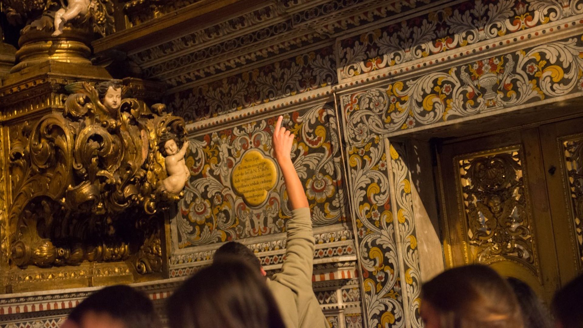 crianças a apontarem para uma capela com temas barrocos na igreja de são roque
