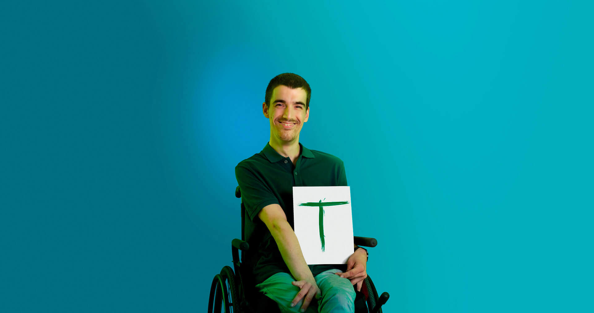 rapaz de cadeira de rodas a segurar em folha de papel com T