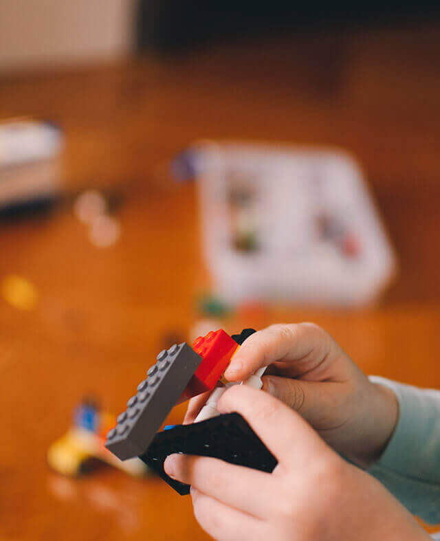 criança a brincar com legos