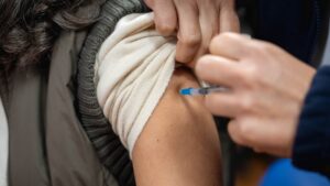 Pessoa leva uma vacina no braço