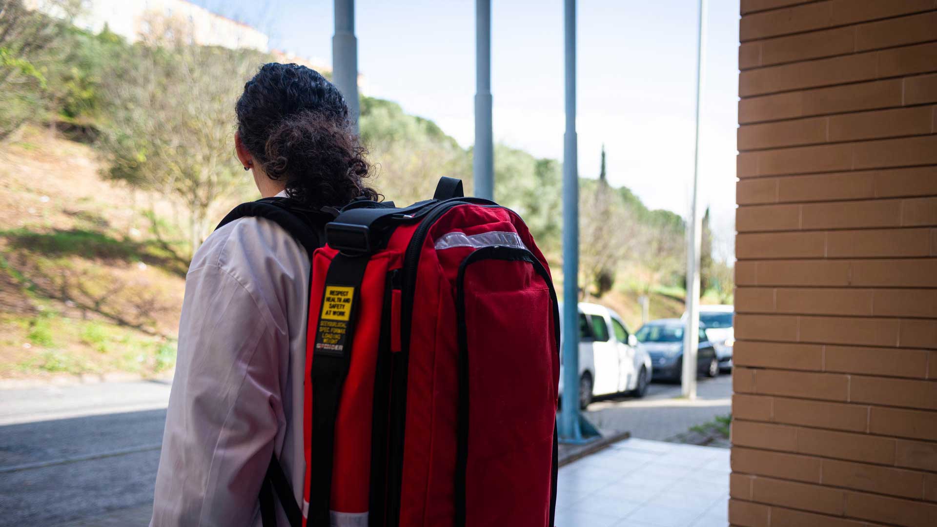 Médica caminha na rua para ir prestar Cuidados de Saúde no Domicílio