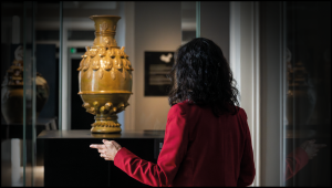 Senhora a olhar para peça no Museu de S. Roque