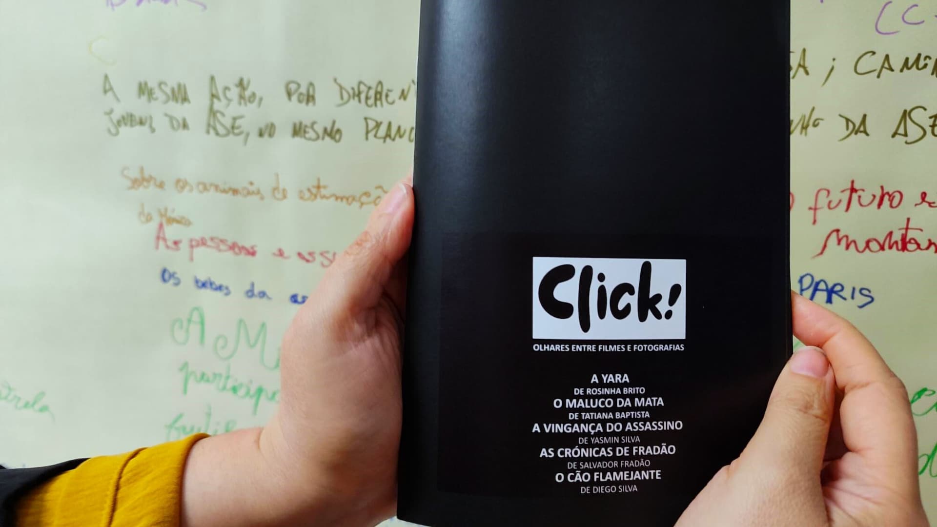 Mãos seguram o fotolivro Click