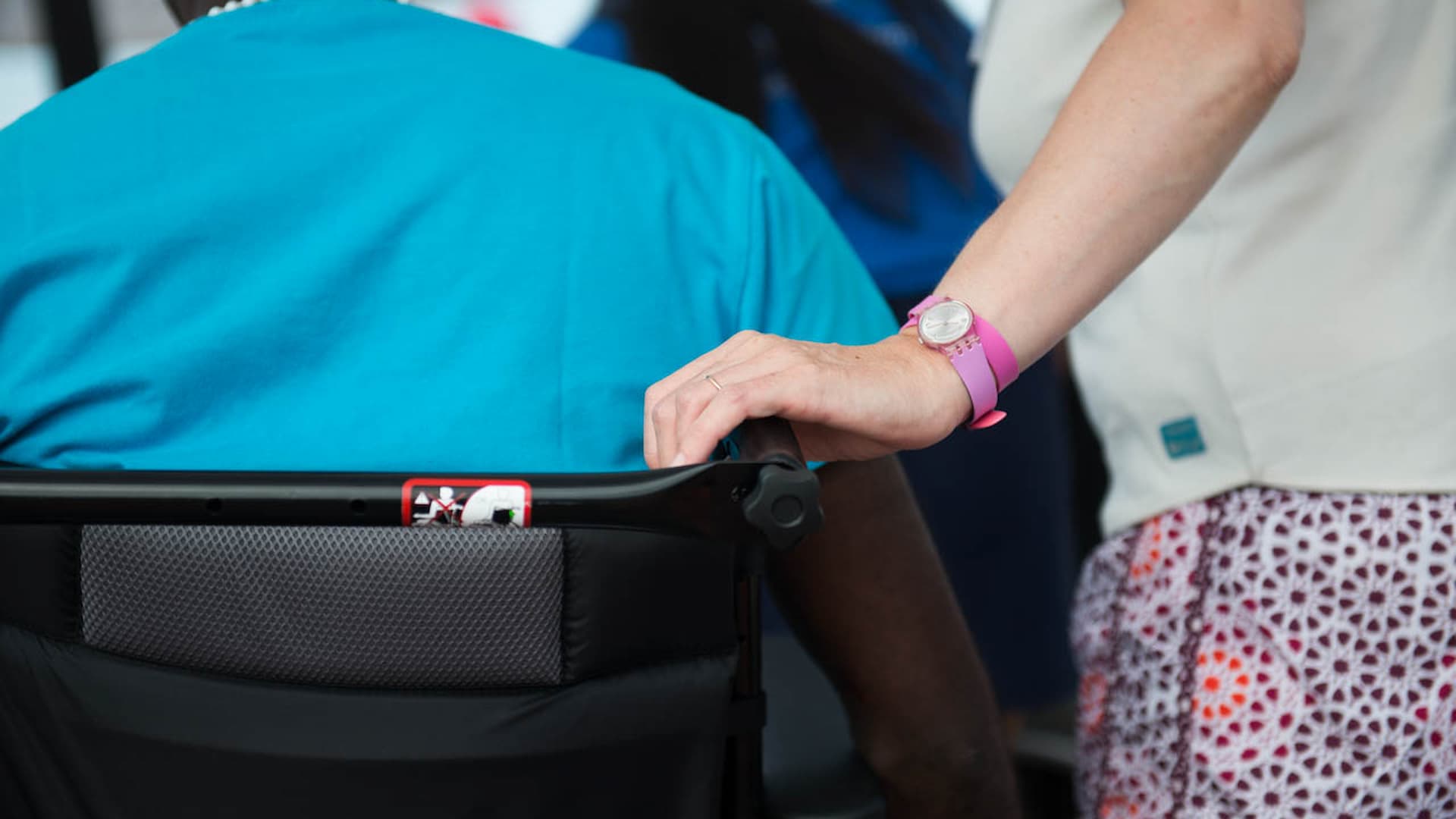 Mão pousada em cadeira de rodas