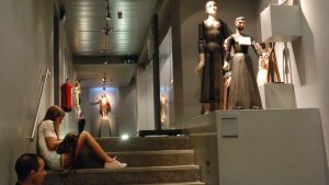 Pessoas sentadas em escadas a ver uma exposição