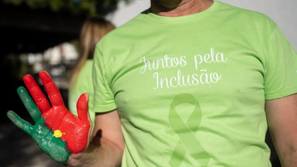 Senhor com a palma da mão pintada com as cores de Portugal