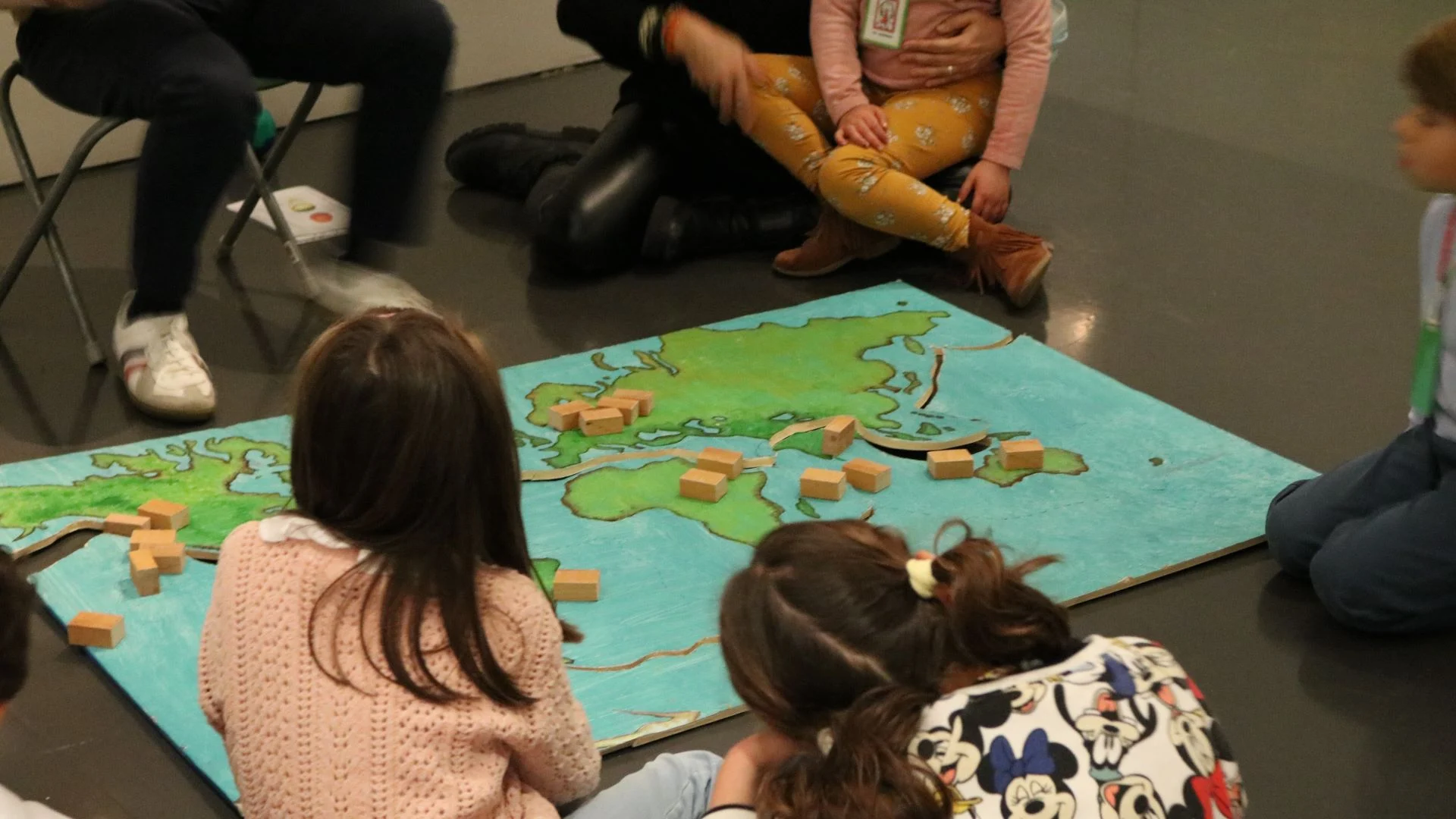 A-terra-treme Crianças sentadas em torno de um desenho do mapa mundo