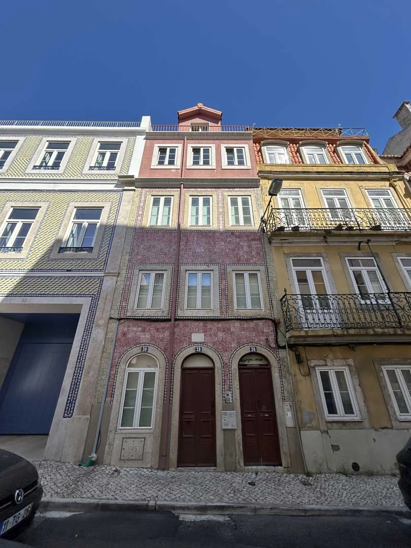 Fachada do prédio estreito revestido a azulejo rosa, com portas em arco, na Rua Silva Carvalho, 26