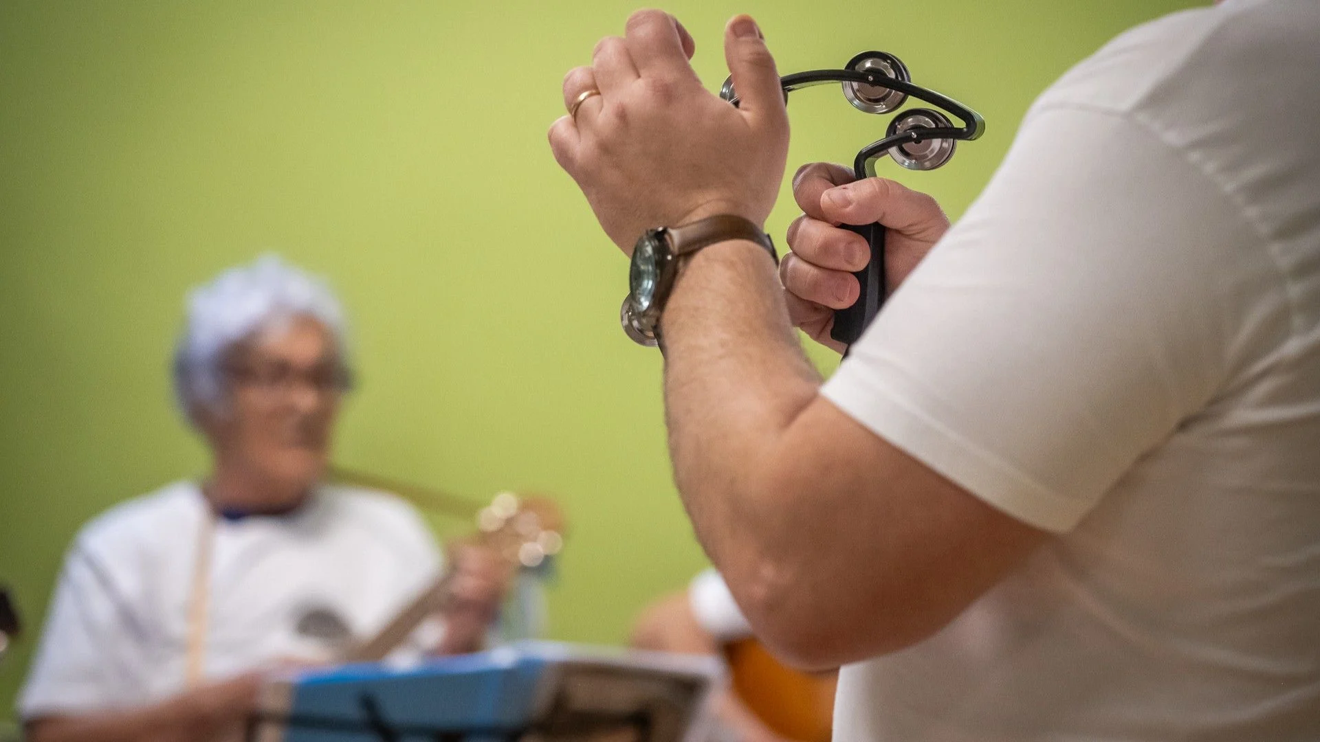 homem a tocar pandeireta; senhora a tocar guitarra