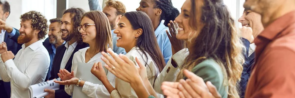 Grupo de pessoas aplaudindo em uma sala