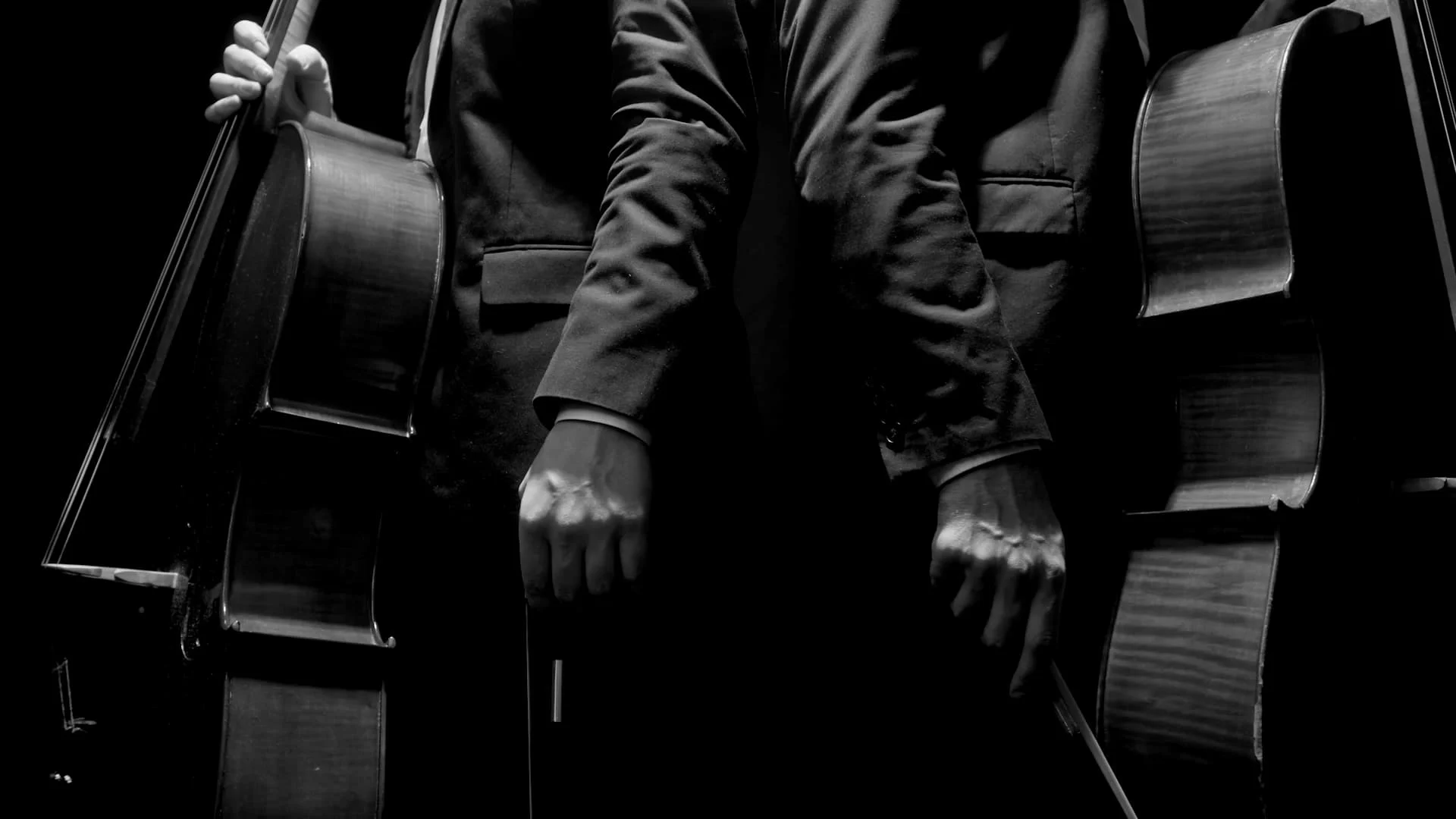 Duas pessoas com violoncelos